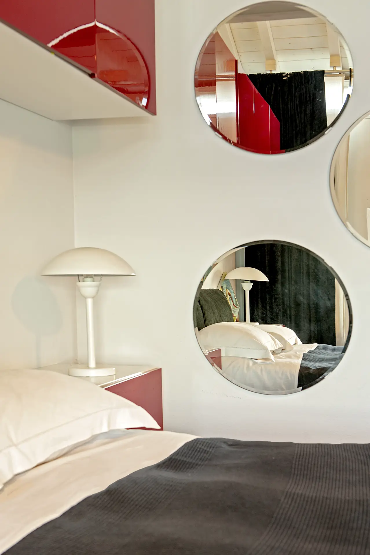 Dettagli di stile: gli specchi circolari richiamano gli oblò di una nave, enfatizzando l'anima marina di questa suite a Calambrone